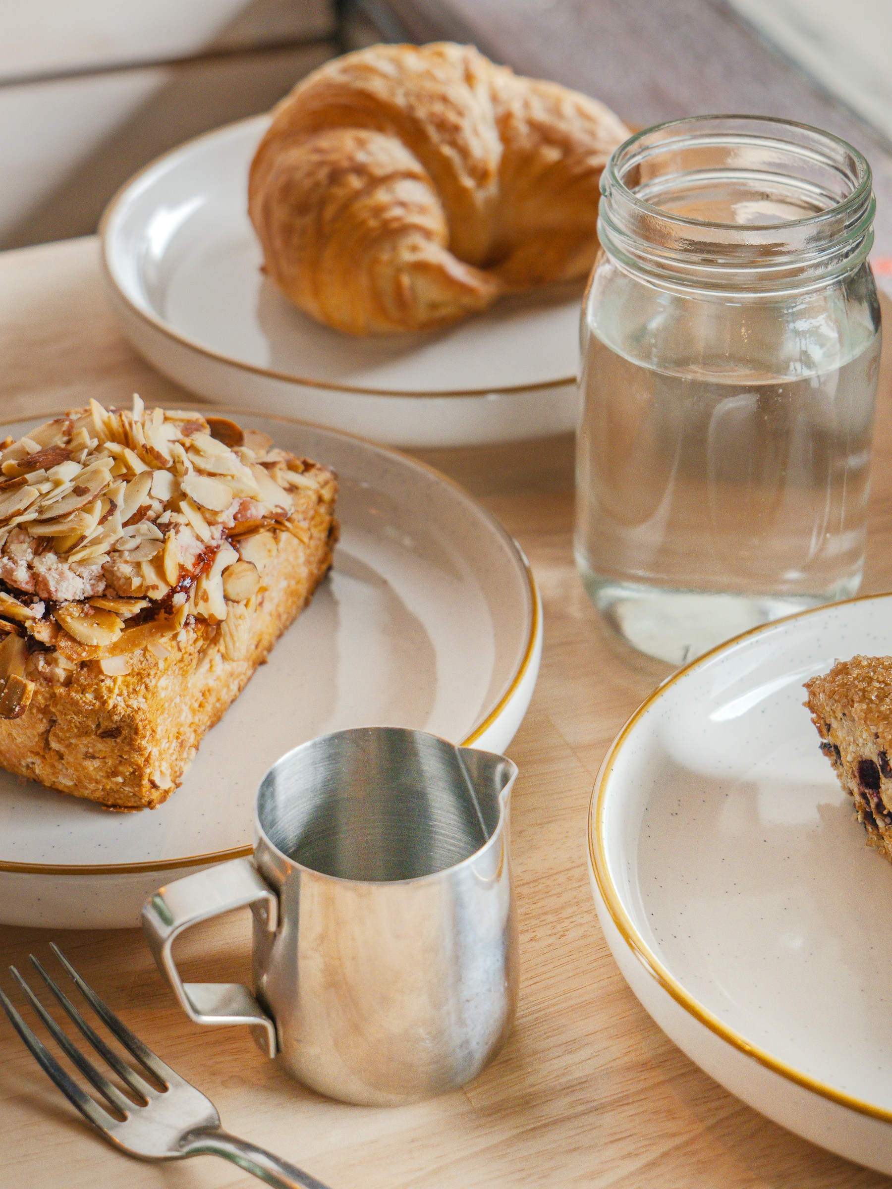 Pastries, a water jar and a metal pitcher arranged on a table
